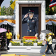 People walk in front of a portrait of king Vajiralongkorn during a rehearsal.